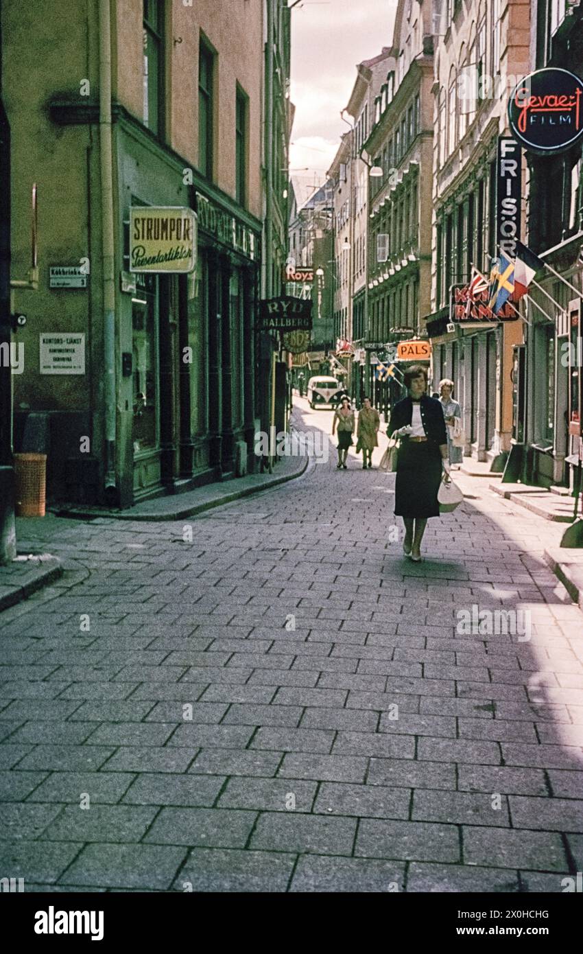 In der VästrlÃ¢nggatan. Passanten laufen in der Gasse, ein Geschäft hat bunte Fähnchen ausgehängt. (Aufnahmedatum: 01.01.1961-31.12.1961) Stock Photo