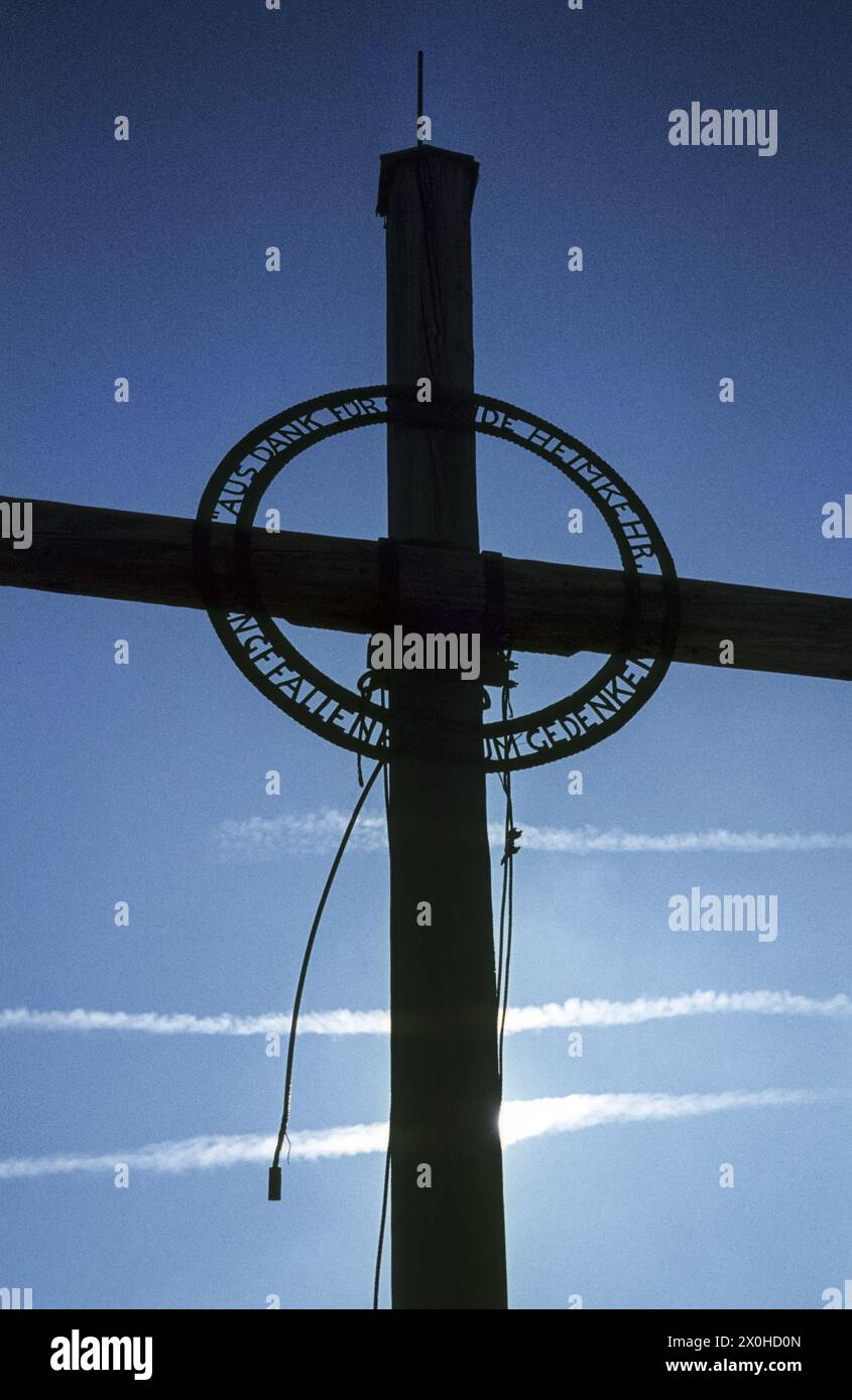 The cross against the blue sky in which contrails can be seen. [automated translation] Stock Photo