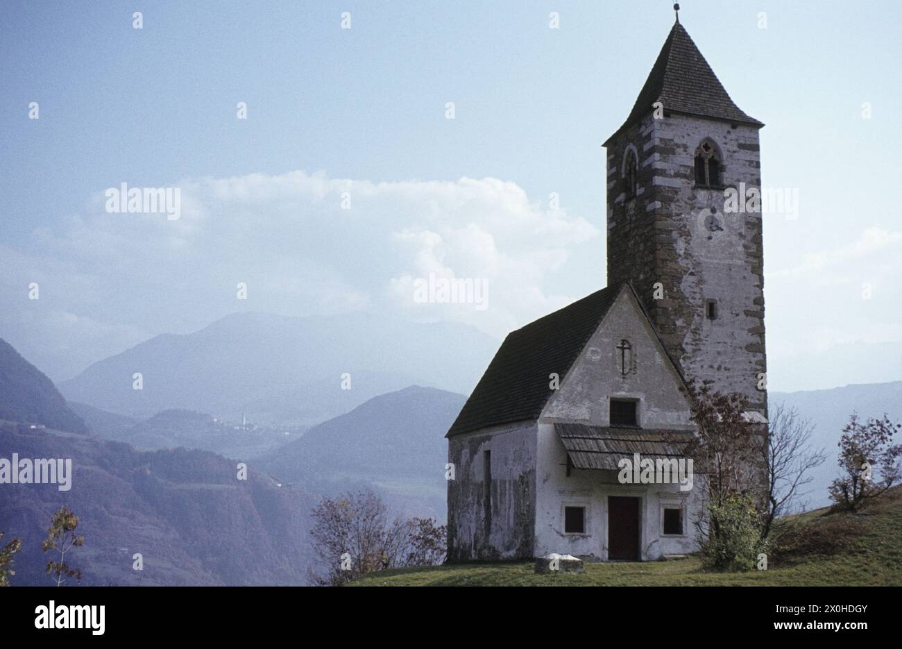 In the background the Grödner valley. St. Verena is one of those churches which, built on a steep rocky outcrop, became successors of pagan places of worship. The sacred building stands on a rocky outcrop, which was once the marker of a much-used road. (undated recording) [automated translation] Stock Photo