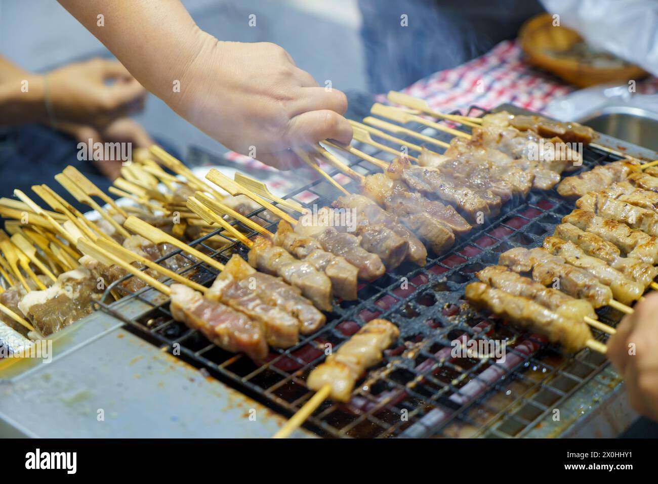 Step into the realm of culinary delight as skewers of succulent meat dance on the grill. The tantalizing aroma wafts through the air, promising a savo Stock Photo