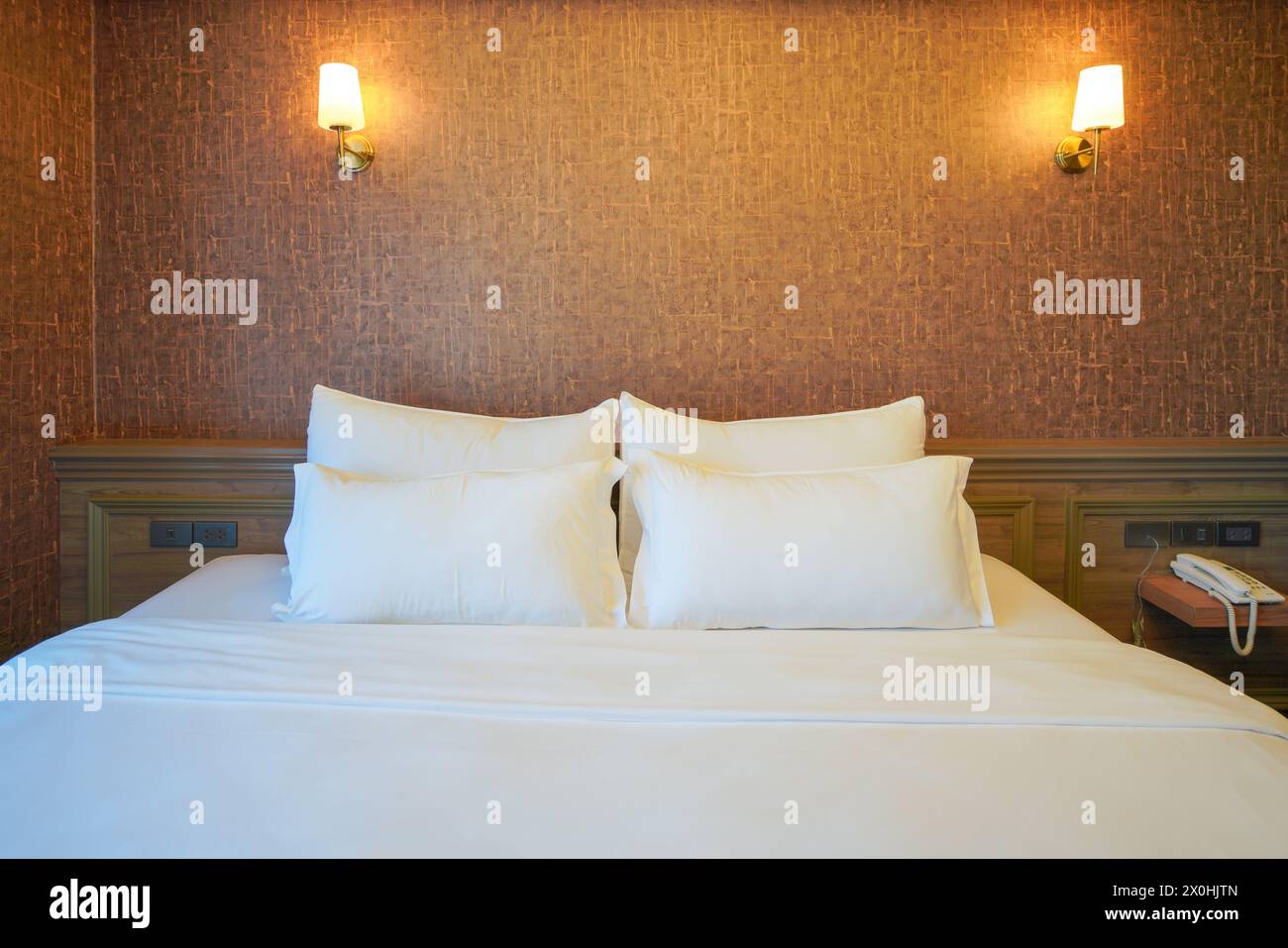 Welcome to a peaceful slumber in this tranquil hotel bedroom that exudes a sense of calm and relaxation. The crisp, white bedding contrasts beautifull Stock Photo