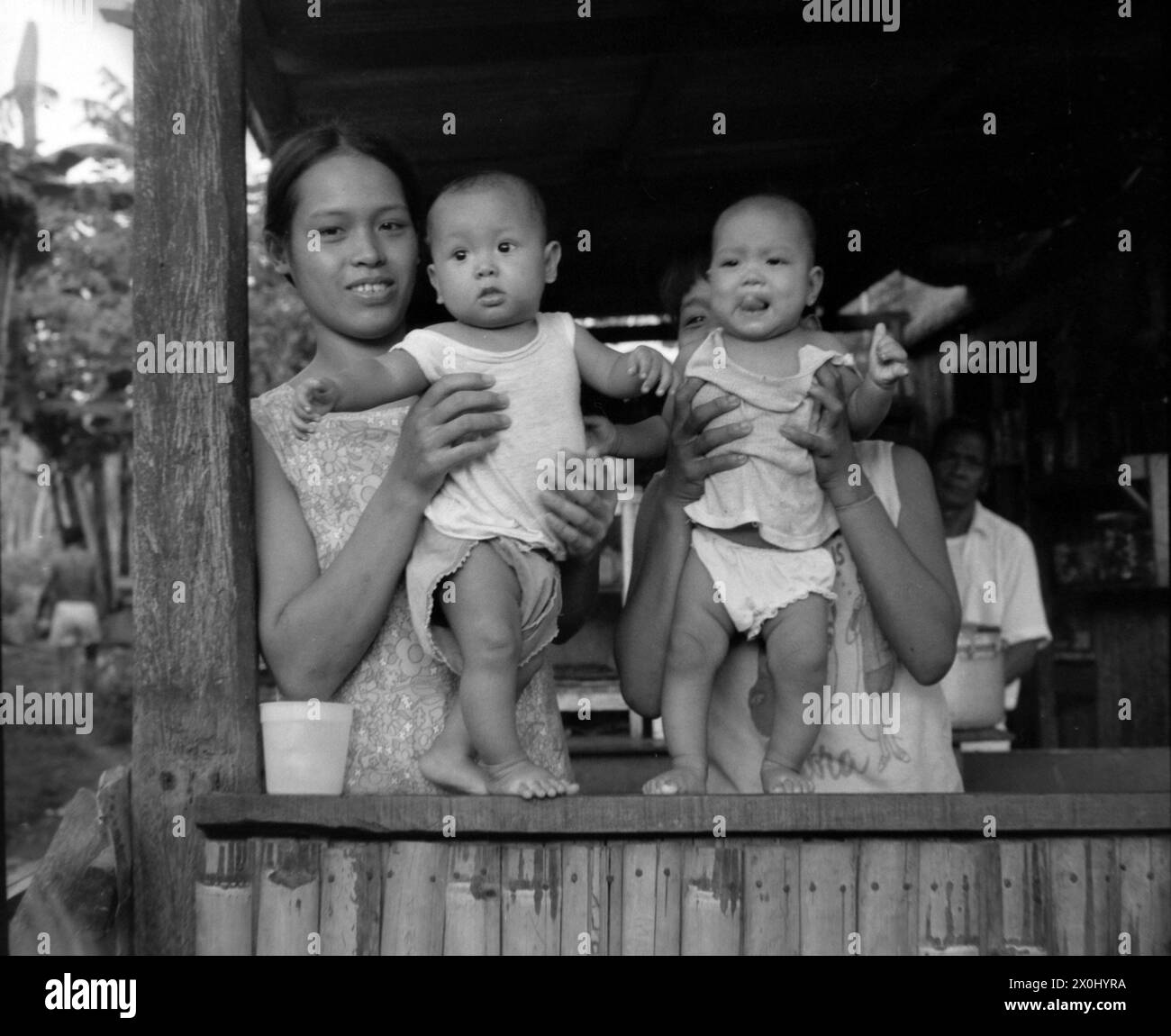 Two young women pose with their babies in Pagsanjan in the Philippines