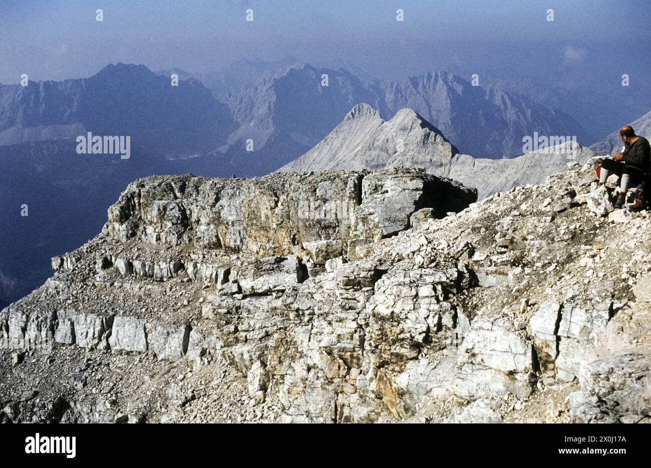 A hiker rests on the summit. Panoramic view of the Karwendel [automated translation] Stock Photo
