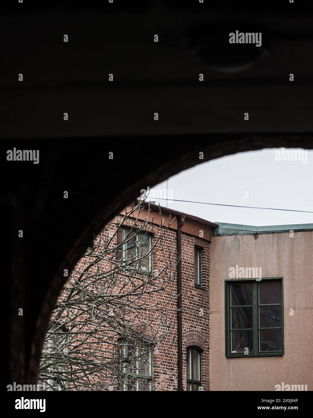 A view through an arch showcasing an old industrial building in ...