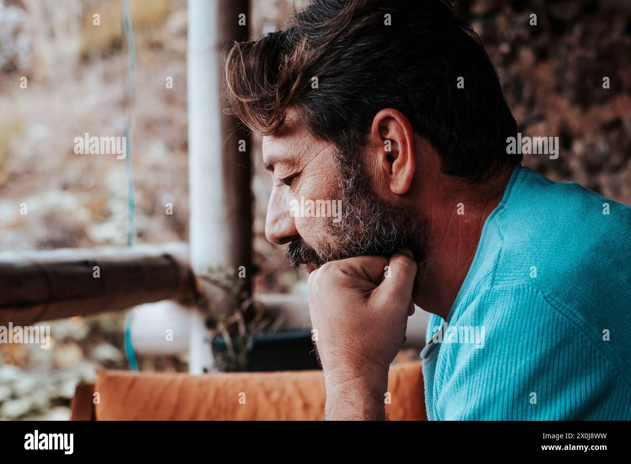 Mature man using and looking mobile phone worried at home. Modern adult people with device cellular technology application sitting indoor. Security and password sign in activity on cell Stock Photo