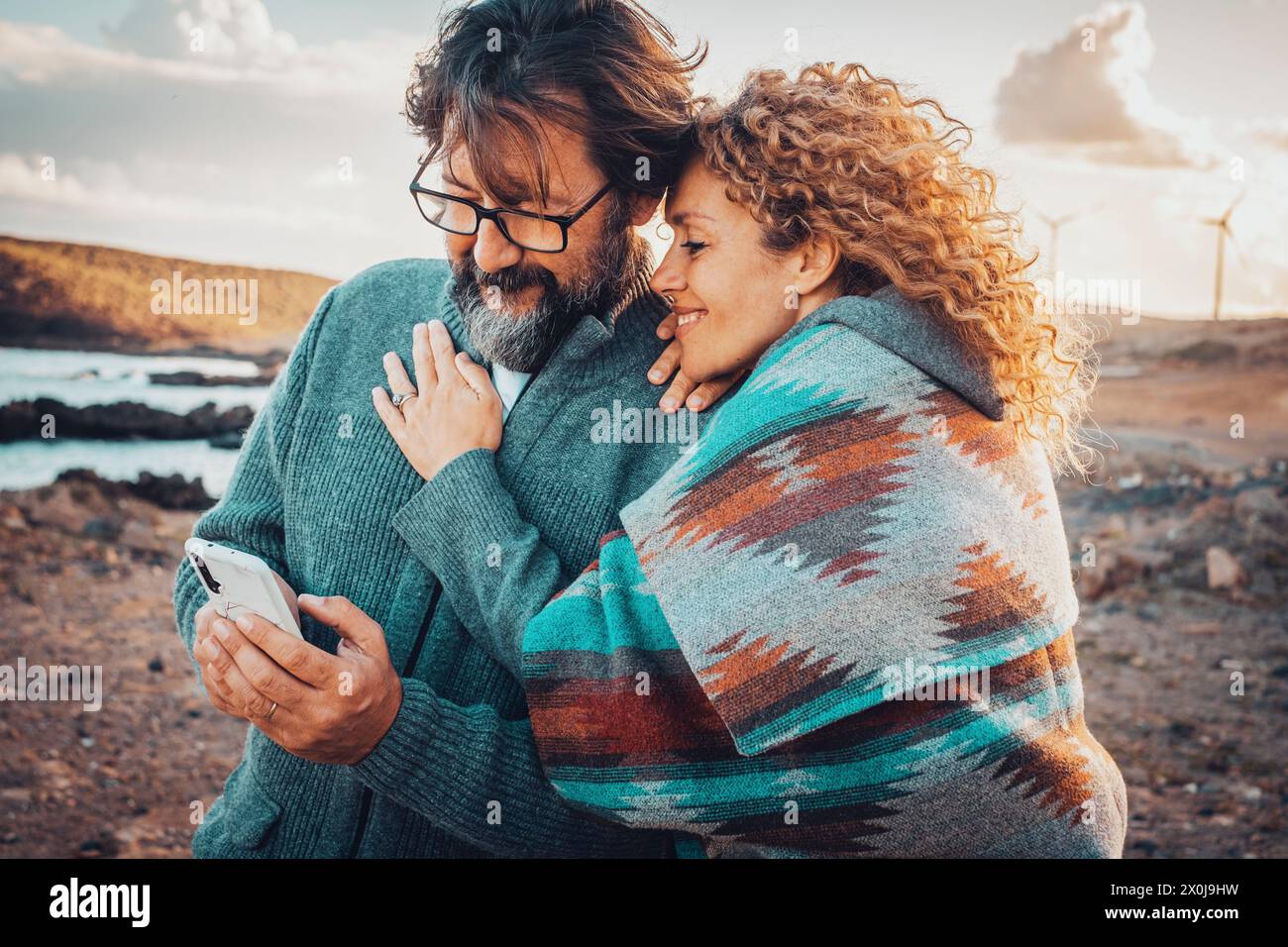 Man and woman using mobile phone connection online in outdoor travel leisure activity together. Happy adult couple enjoy technology and roaming communication. Travel adventure vacation lifestyle Stock Photo