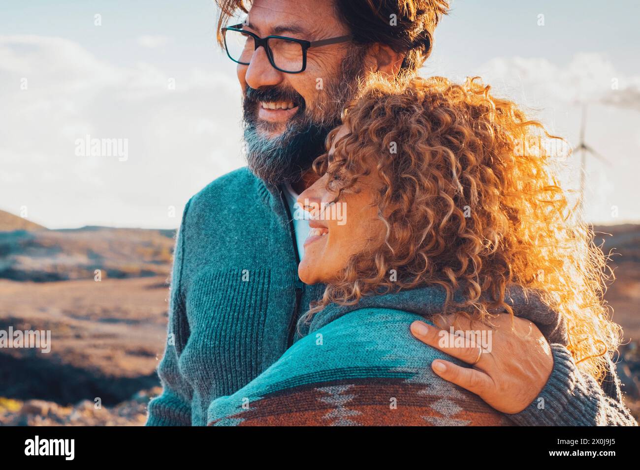 Happy traveler adult couple enjoy outdoor leisure activity in desert coastline beach destination together with love and adventure lifestyle. Man hugging woman happy people in relationship outside Stock Photo