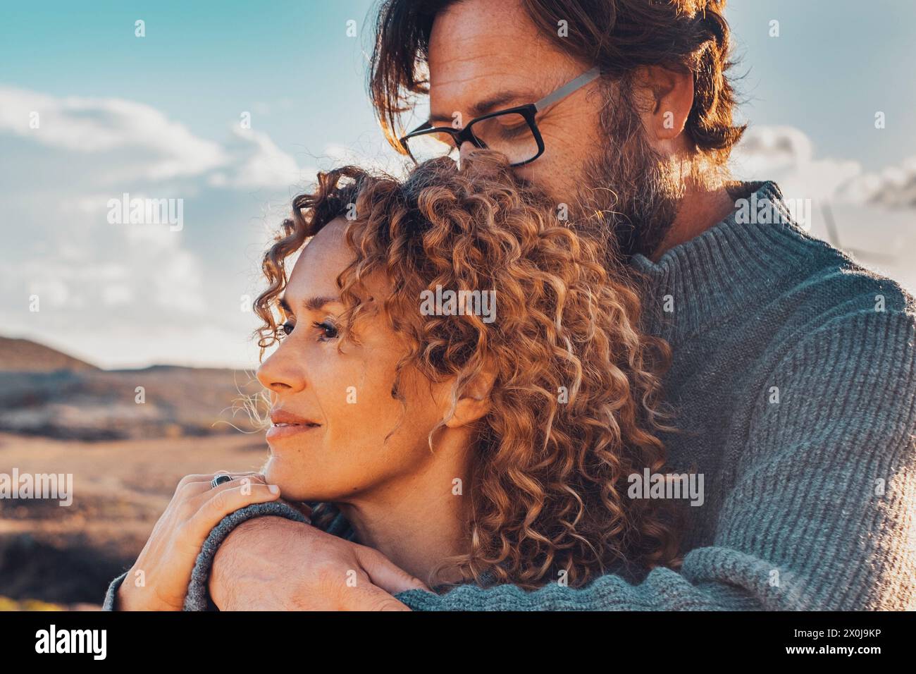 Young adult couple in love in outdoor leisure activity admiring travel destination. Contemplation. People traveler and adventure lifestyle. Man hug woman from behind. Looking away, togetherness two Stock Photo