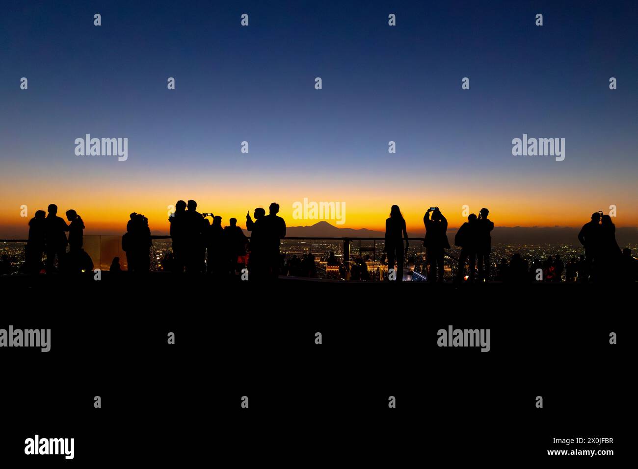 Silhouettes of people against a vibrant sunset , fuji mountain on background Stock Photo
