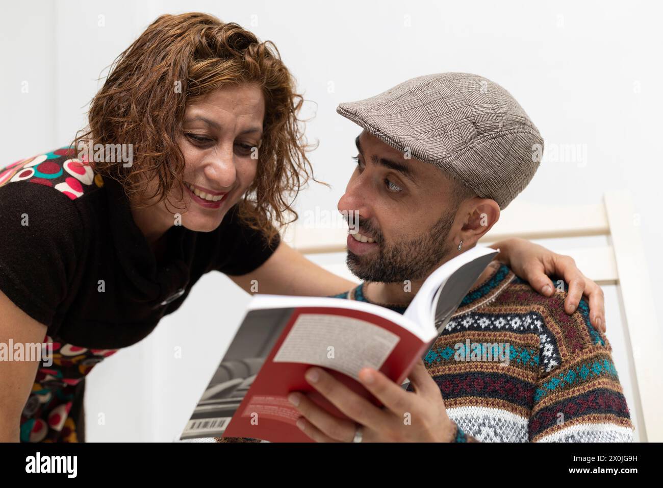 Latin American couple sharing with a positive attitude reading a book Stock Photo