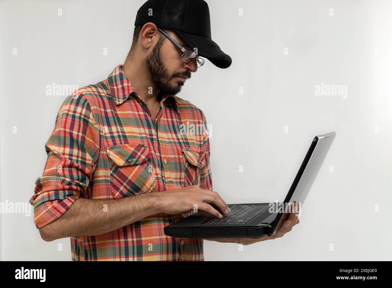 Latin American man with his laptop computer is a programmer and specializes in web development. Stock Photo