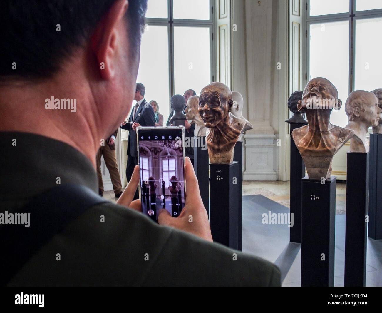 Vienna, Austria, Austria. 12th Apr, 2024. Tourists take a photo of the character heads of FRANZ XAVER MESSERSCHMIDT, inside the Upper Belvedere Palace in Vienna. The Upper Belvedere palace is one of the world's first public museums, opening in 1777. It houses some of the most coveted artwork and most diversified collections in Europe. (Credit Image: © Bianca Otero/ZUMA Press Wire) EDITORIAL USAGE ONLY! Not for Commercial USAGE! Stock Photo