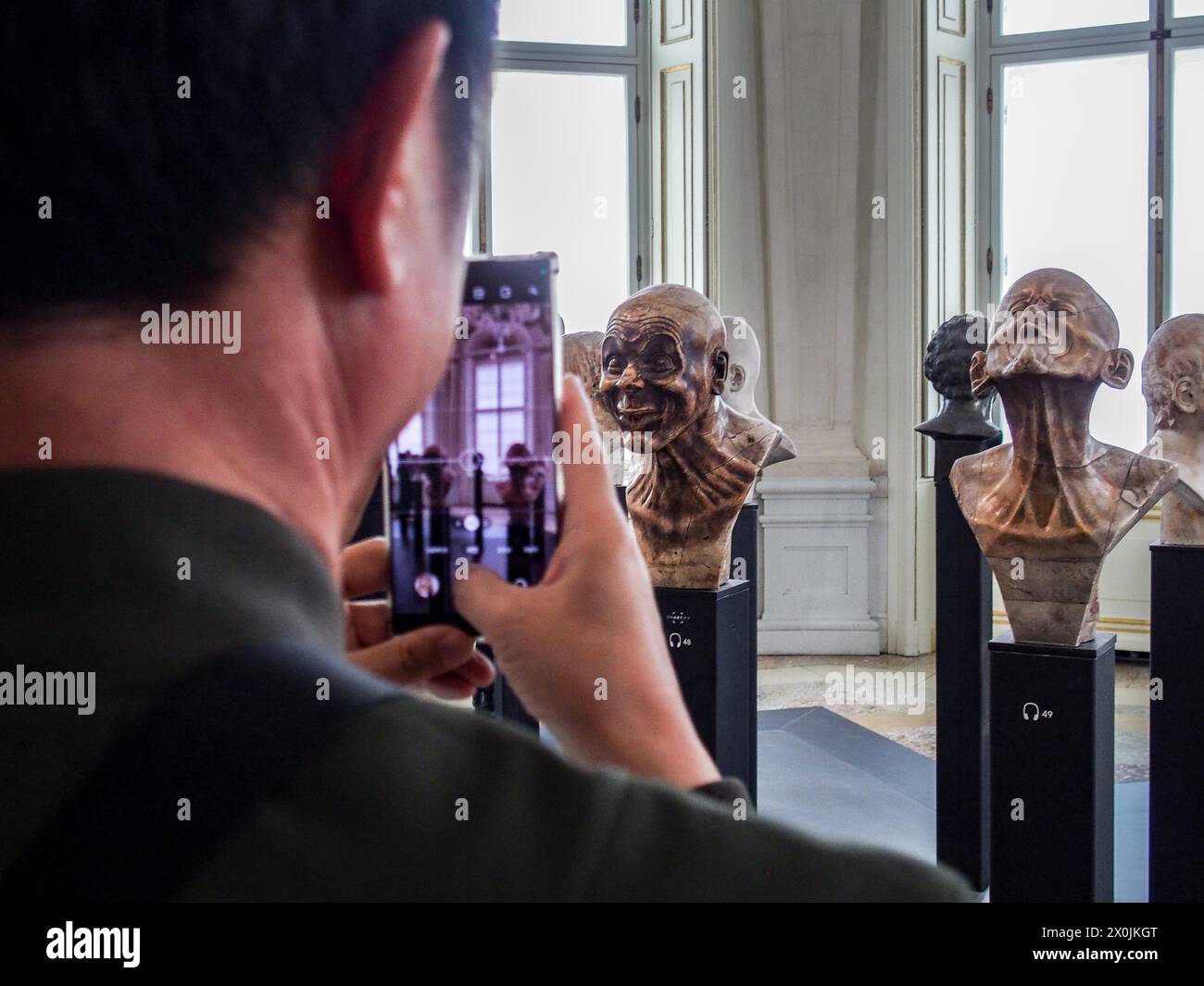 Vienna, Austria, Austria. 12th Apr, 2024. Tourists take a photo of the character heads of FRANZ XAVER MESSERSCHMIDT, inside the Upper Belvedere Palace in Vienna. The Upper Belvedere palace is one of the world's first public museums, opening in 1777. It houses some of the most coveted artwork and most diversified collections in Europe. (Credit Image: © Bianca Otero/ZUMA Press Wire) EDITORIAL USAGE ONLY! Not for Commercial USAGE! Stock Photo