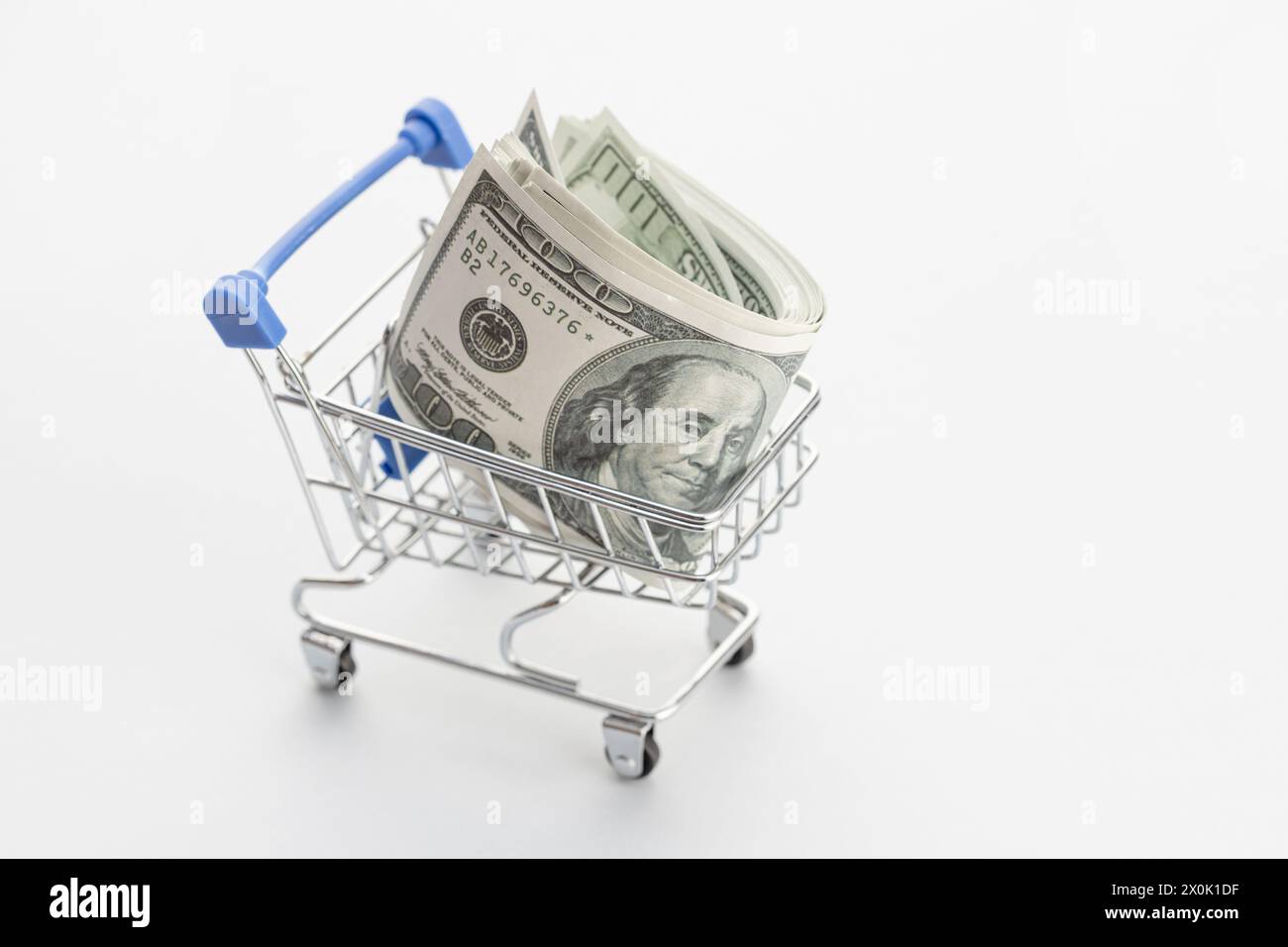 Shopping cart with a bunch of dollar banknotes. Wealth, saving, income concept Stock Photo