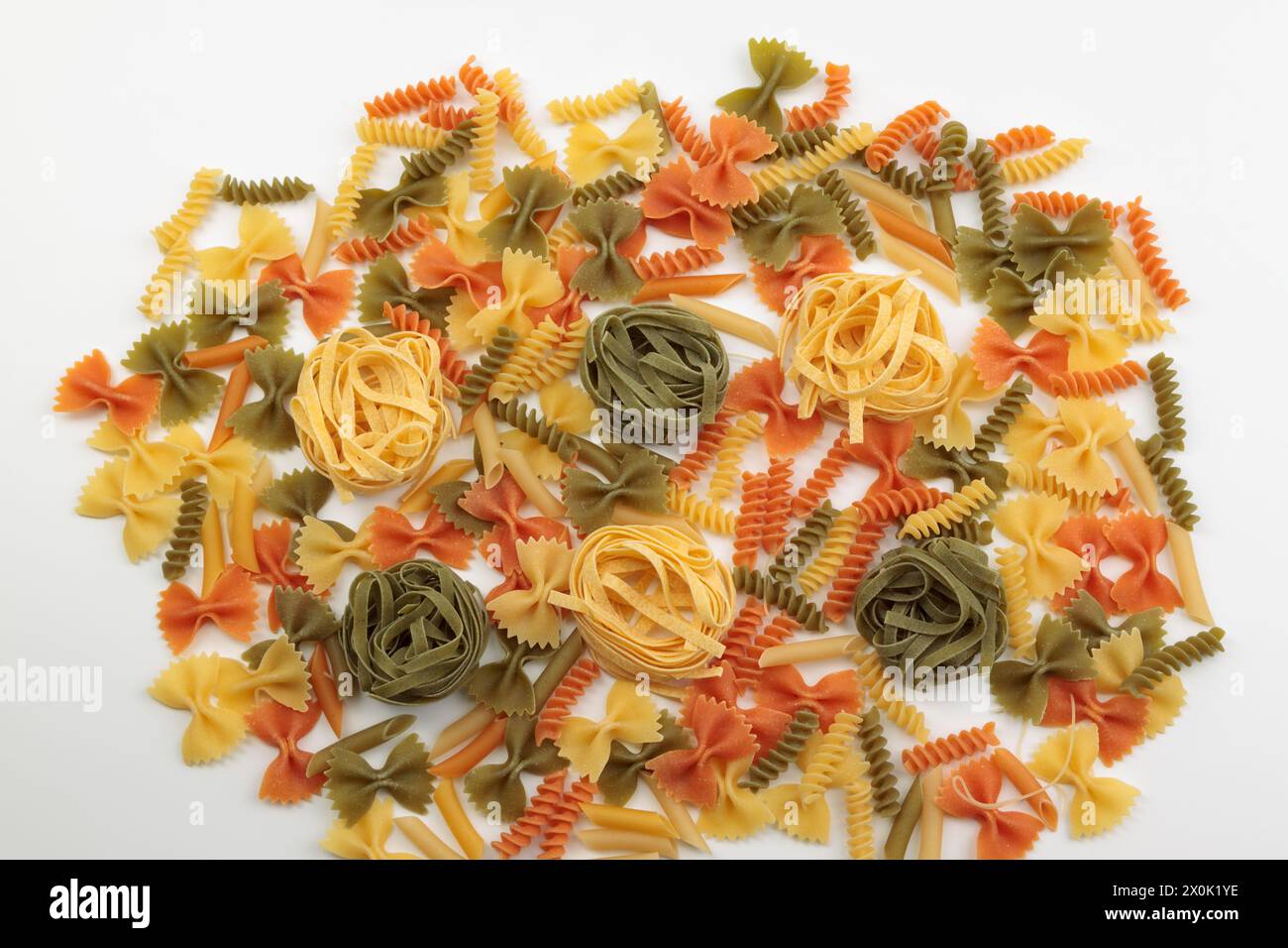 Tricolor macaroni of different types. It is located on a white surface ...