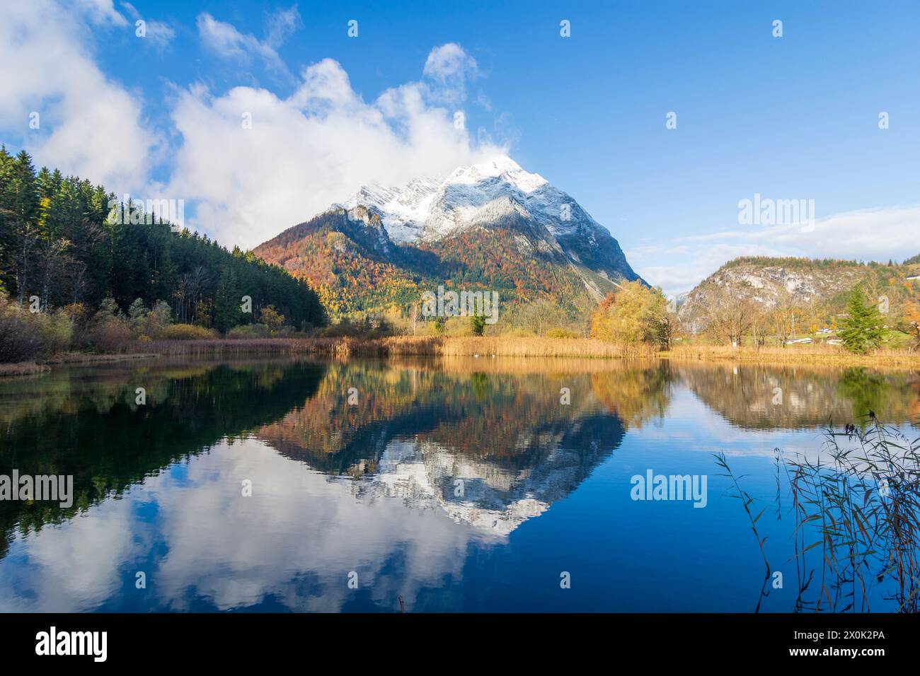 Stainach-Pürgg, snow covered mountain Grimming, fish pond in Schladming-Dachstein, Styria, Austria Stock Photo