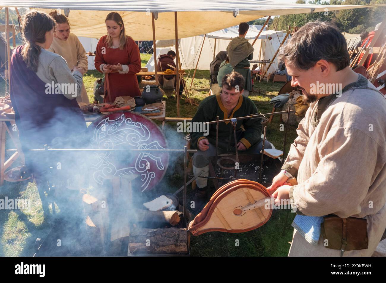 England, East Sussex, Battle, The Annual October Battle of Hastings Re-enactment Festival, Camp Scene with Men Cooking Using Traditional Method Stock Photo