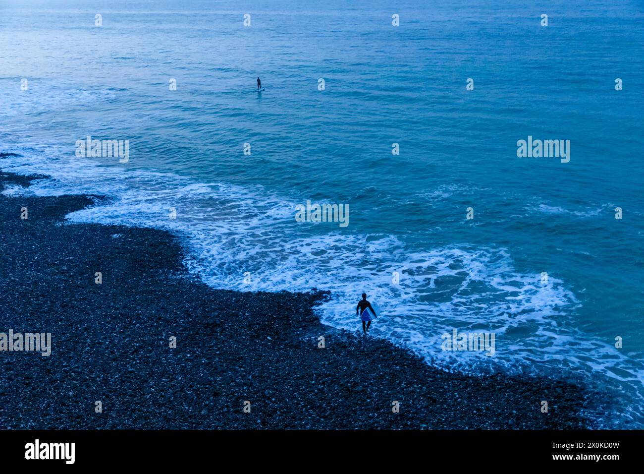 England, East Sussex, Eastbourne, South Downs National Park, Paddle Boarder and Surfer at Burling Gap Stock Photo