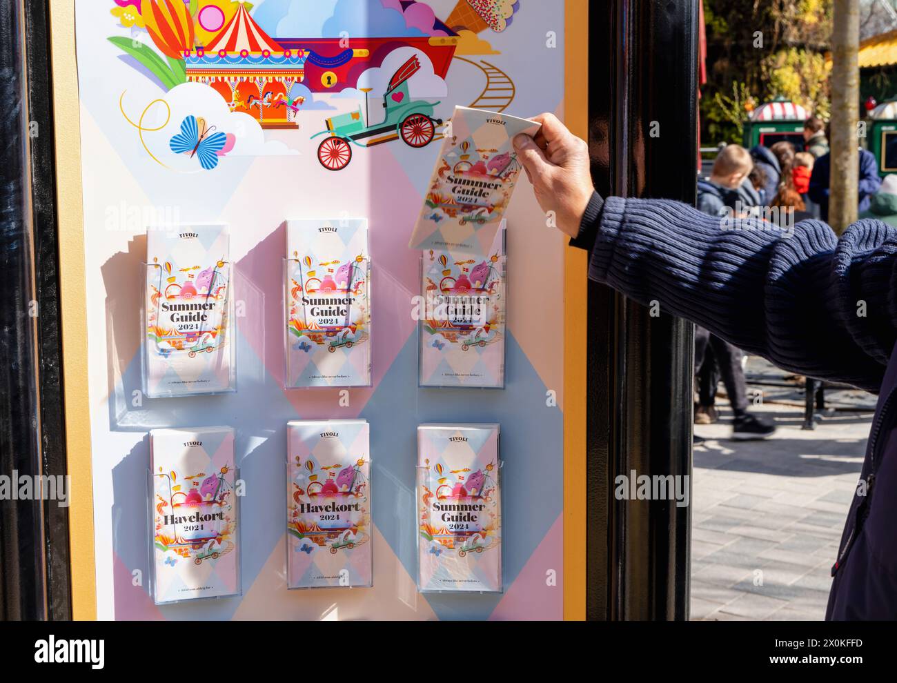 Amusement Program A man takes a brochure of the Tivoli amusement park program. Copenhagen ...