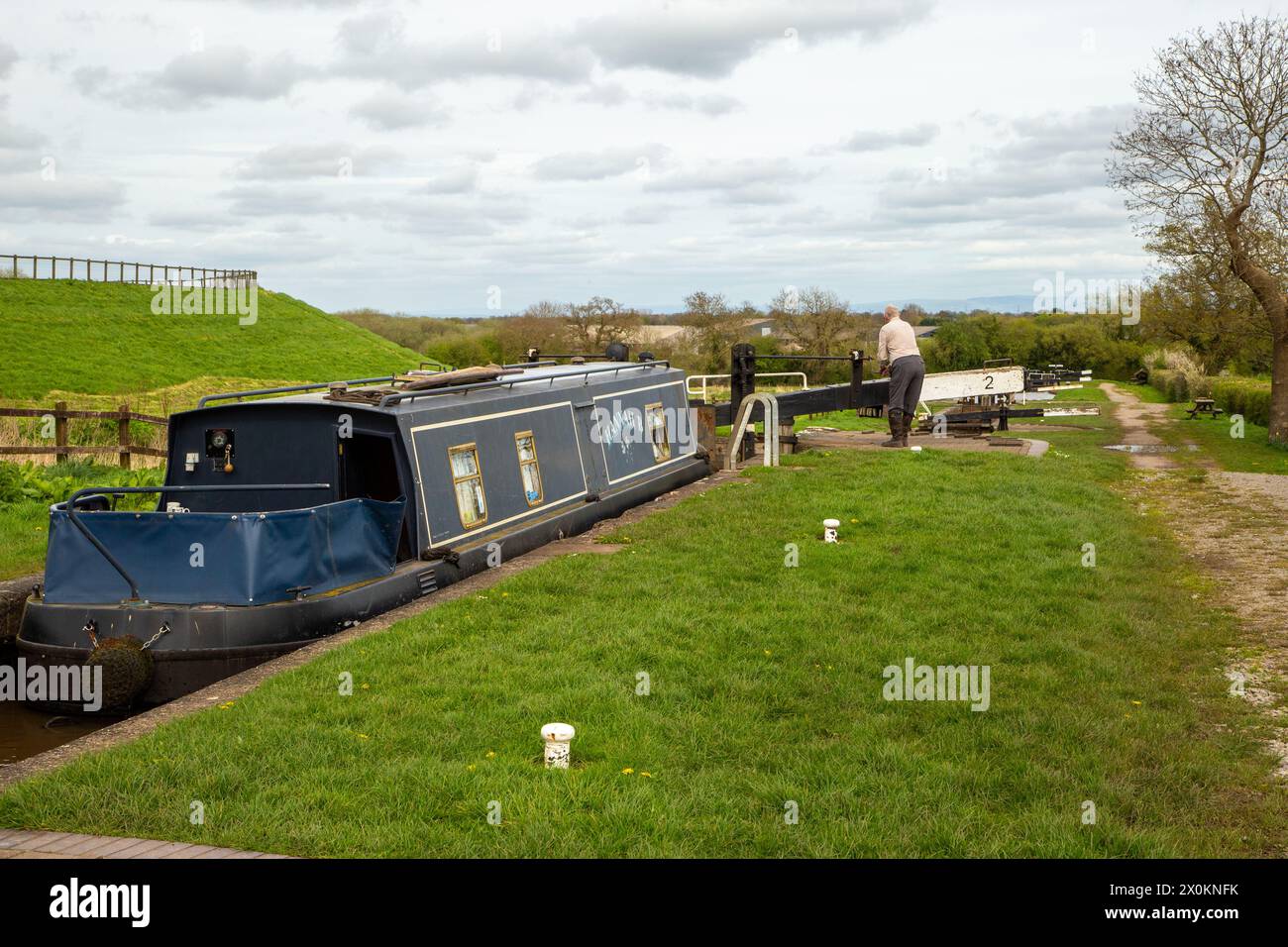 Man winding locks on the Llangollen canal at Hurleston junction while passing through Cheshire on his narrowboat holiday Stock Photo
