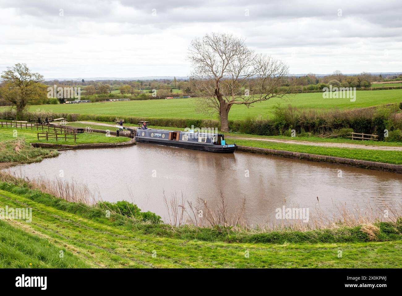 Canal narrowboat passing through the Hurleston flight of lock on the Llangollen canal after leaving the Shropshire Union canal at Hurleston junction Stock Photo