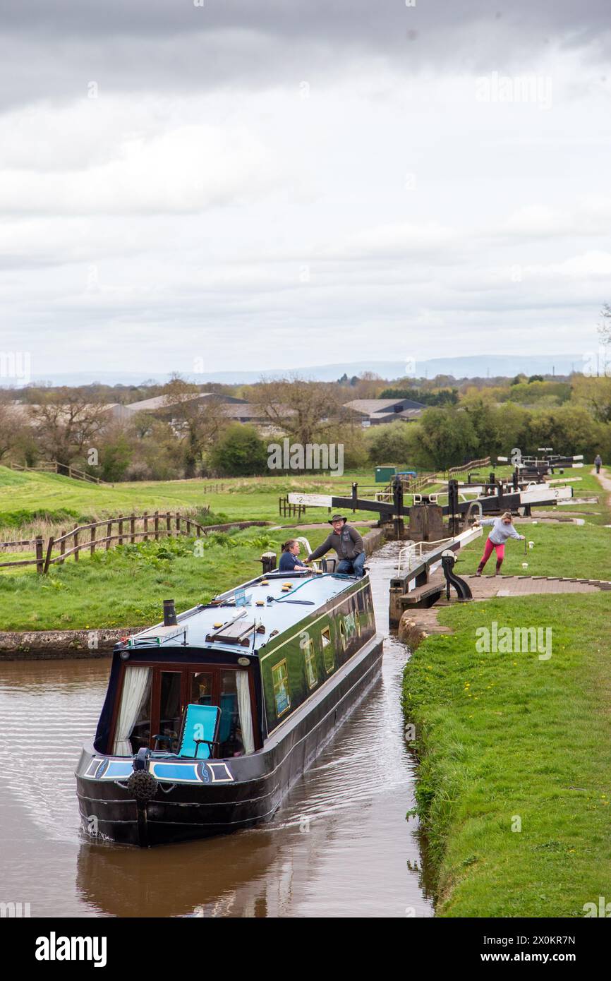 Canal narrowboat passing through the Hurleston flight of lock on the Llangollen canal after leaving the Shropshire Union canal at Hurleston junction Stock Photo