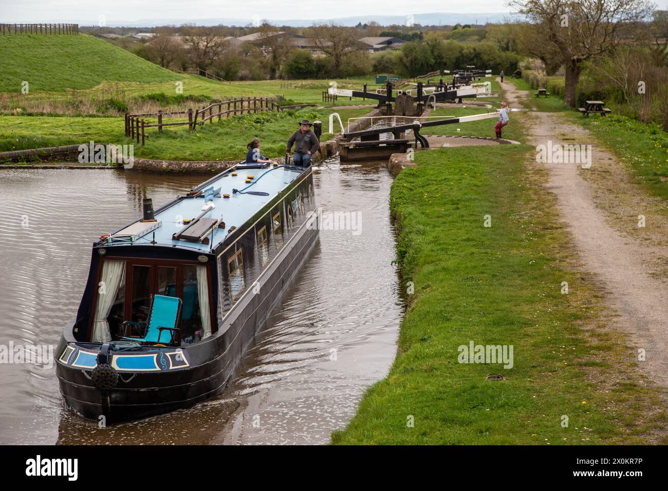 Canal narrowboat passing through the Hurleston flight of lock on the Llangollen canal after leaving the Shropshire Union canal at Hurleston junction Stock Photo