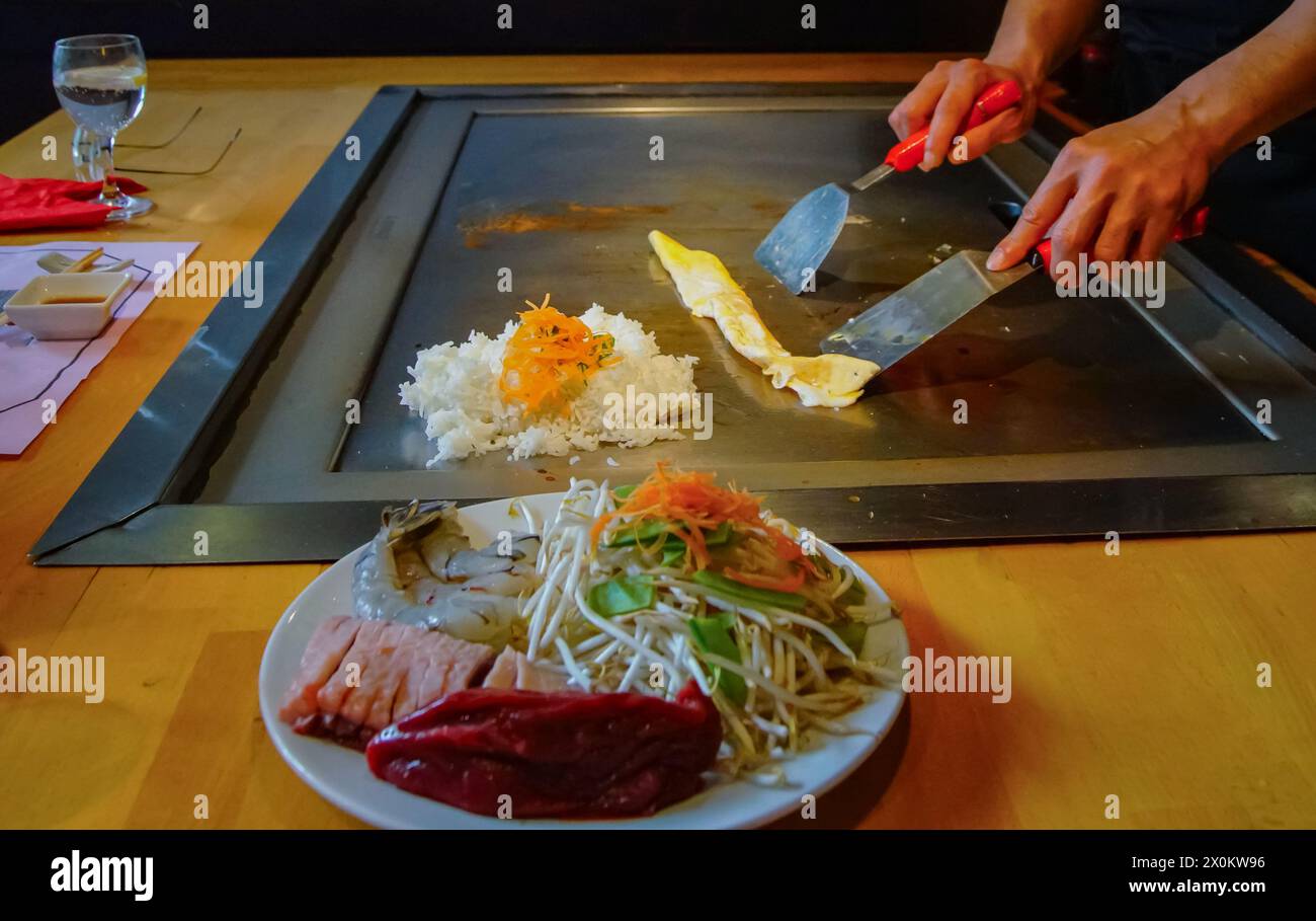 chef's hands with spatula over teppanyaki. cooking vegetables meat and