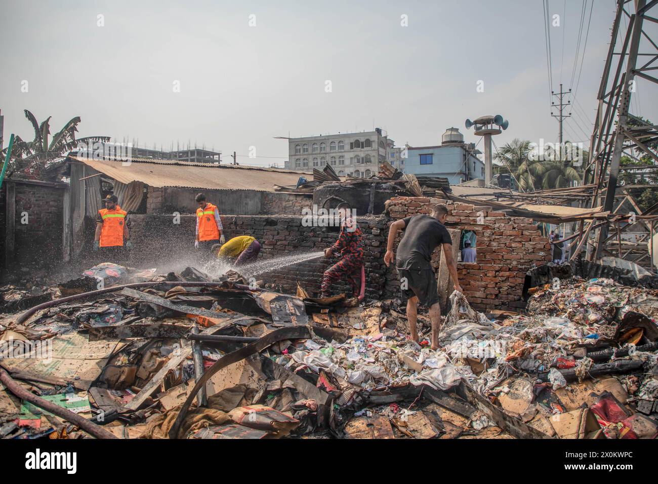Firefighters and people work to douse a fire that broke out in tin-shed ...