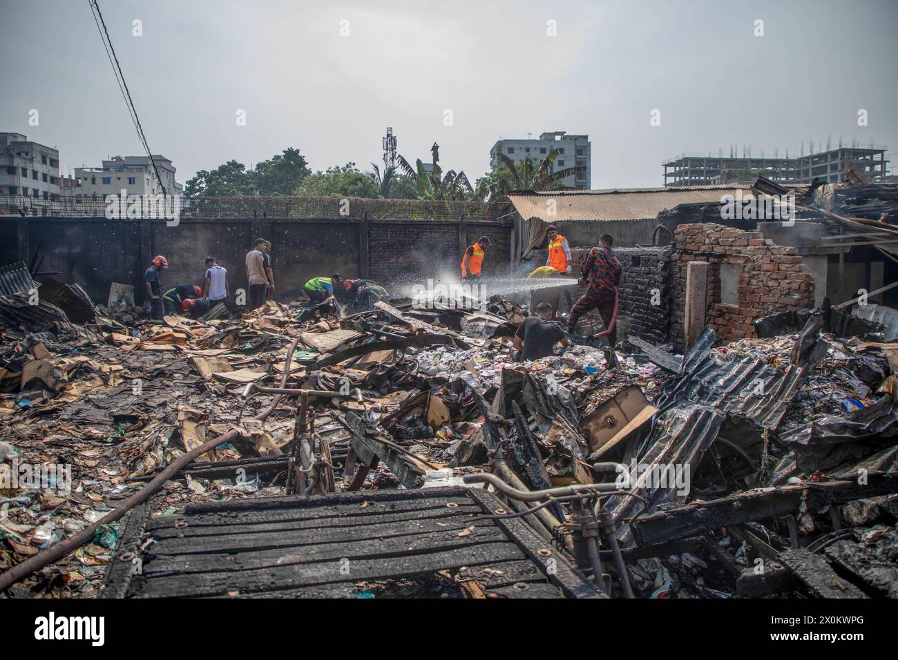 Firefighters and people work to douse a fire that broke out in tin-shed ...