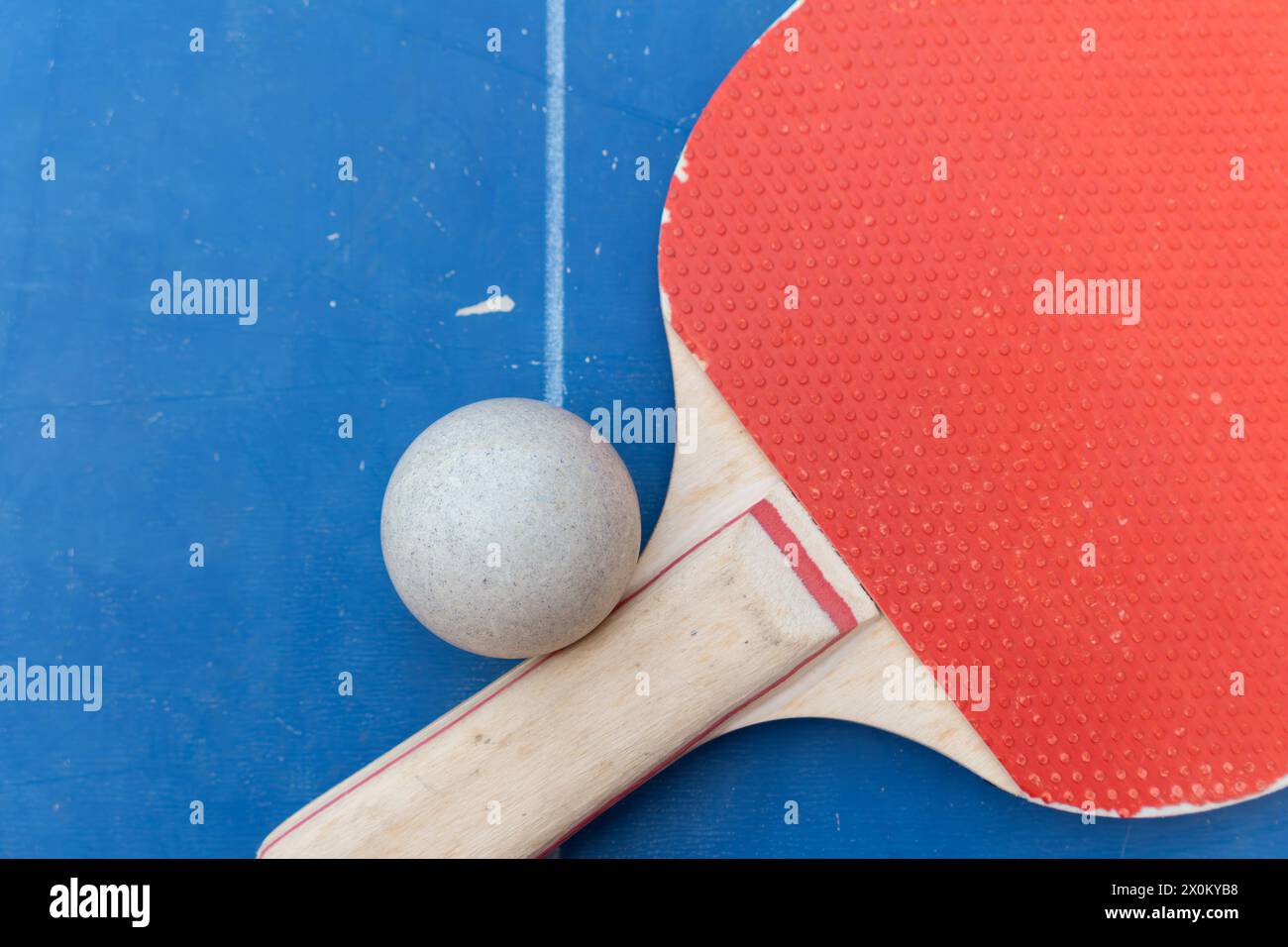 top view pingpong racket and ball and net on a blue pingpong table at horizontal composition Stock Photo