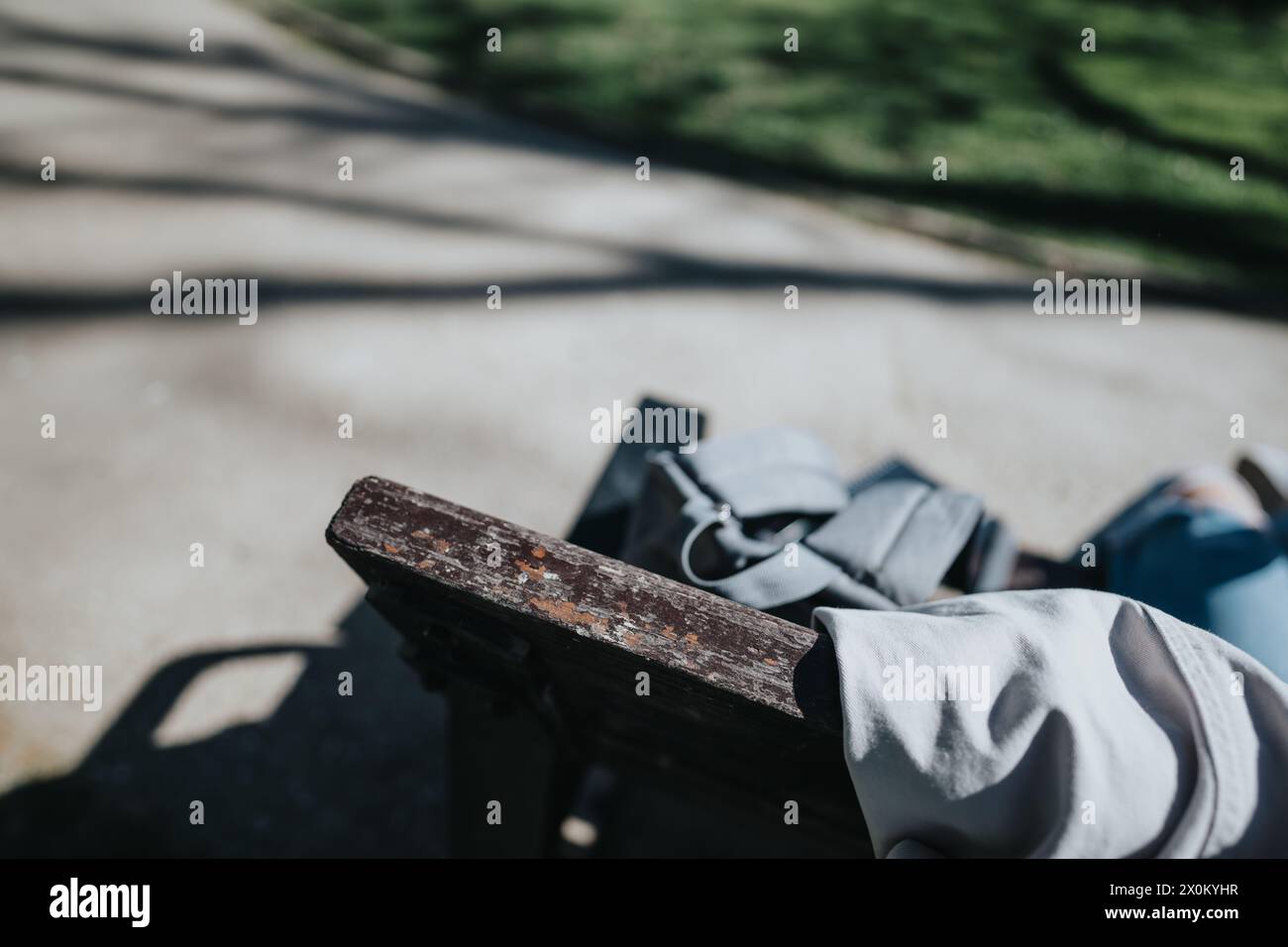 Student resting on a bench in outdoor park with backpack Stock Photo