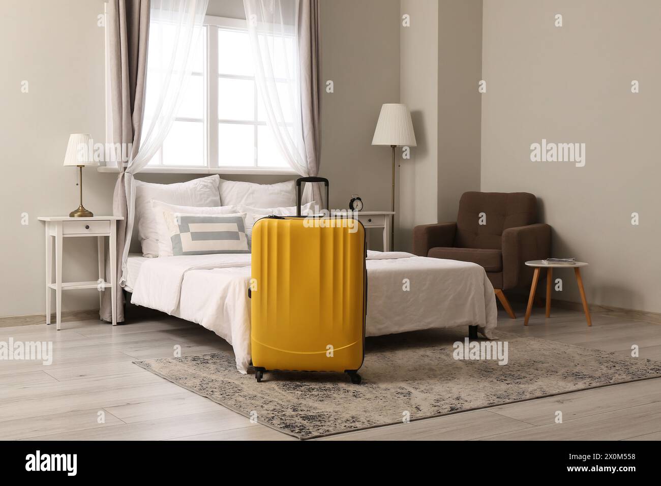 Interior of hotel room with suitcase near bed Stock Photo