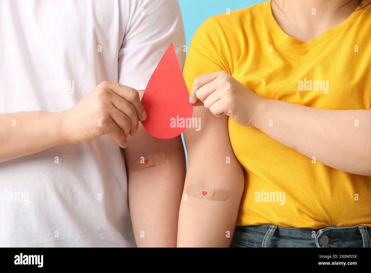 Donors with applied medical patches and paper blood drop on blue background Stock Photo