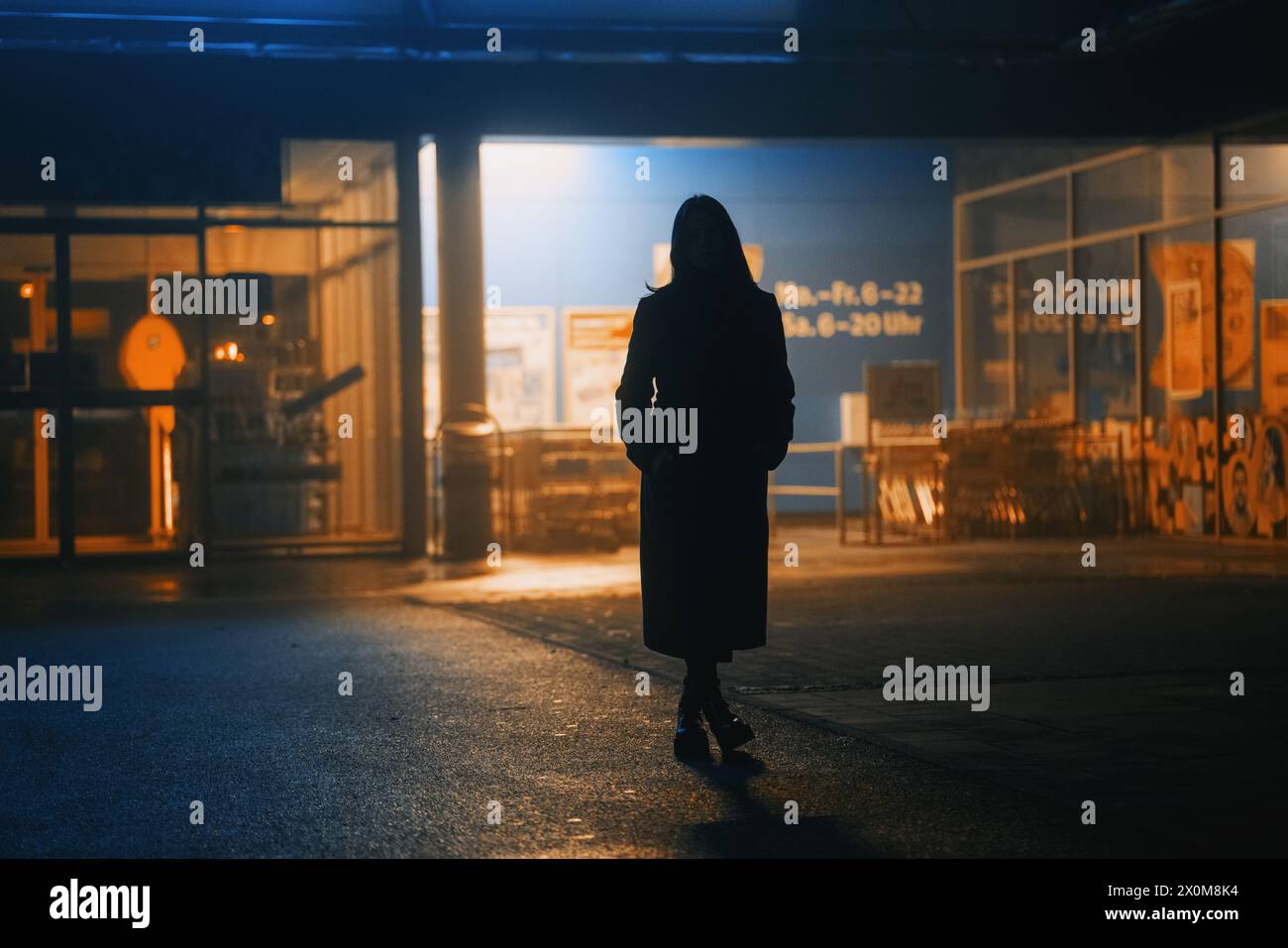 Silhouette of a young woman in a long coat. Stock Photo