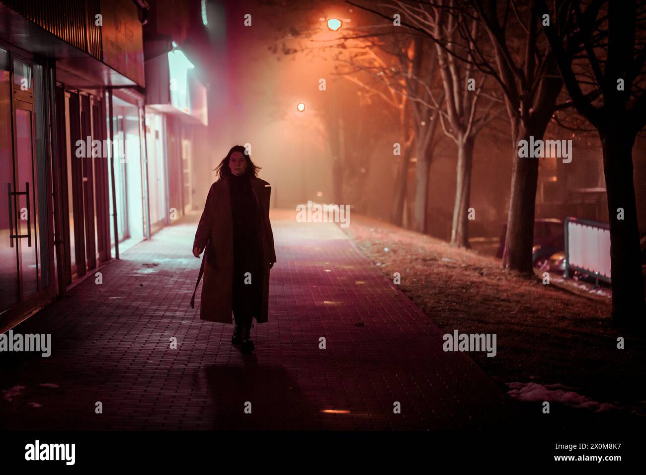 Young woman walking through a city at night Stock Photo - Alamy