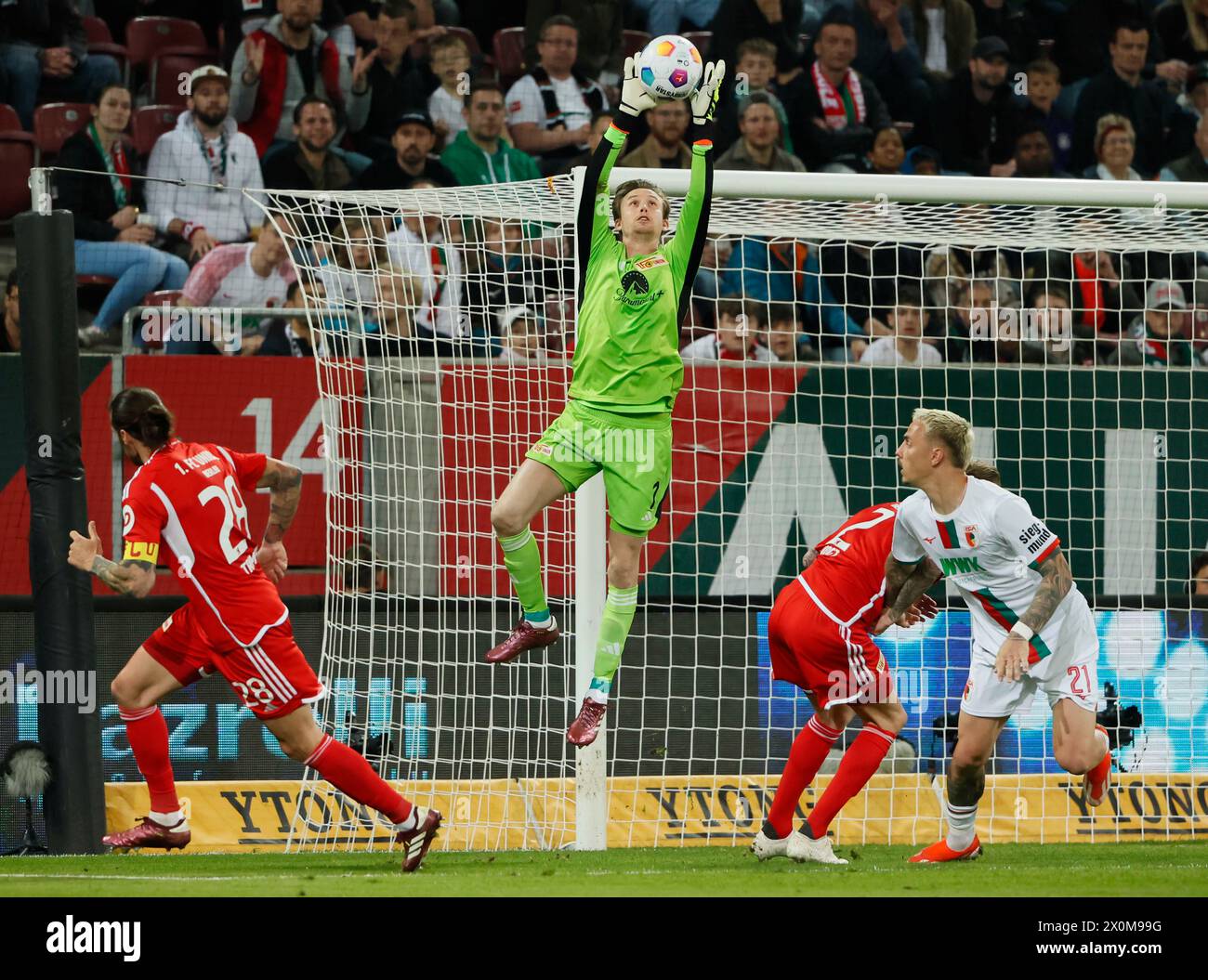 Augsburg, Germany. 12th Apr, 2024. Frederik Ronnow (2nd L), goalkeeper of Union Berlin, makes a save during the German first division Bundesliga football match between FC Augsburg and Union Berlin in Augsburg, Germany, April 12, 2024. Credit: Philippe Ruiz/Xinhua/Alamy Live News Stock Photo