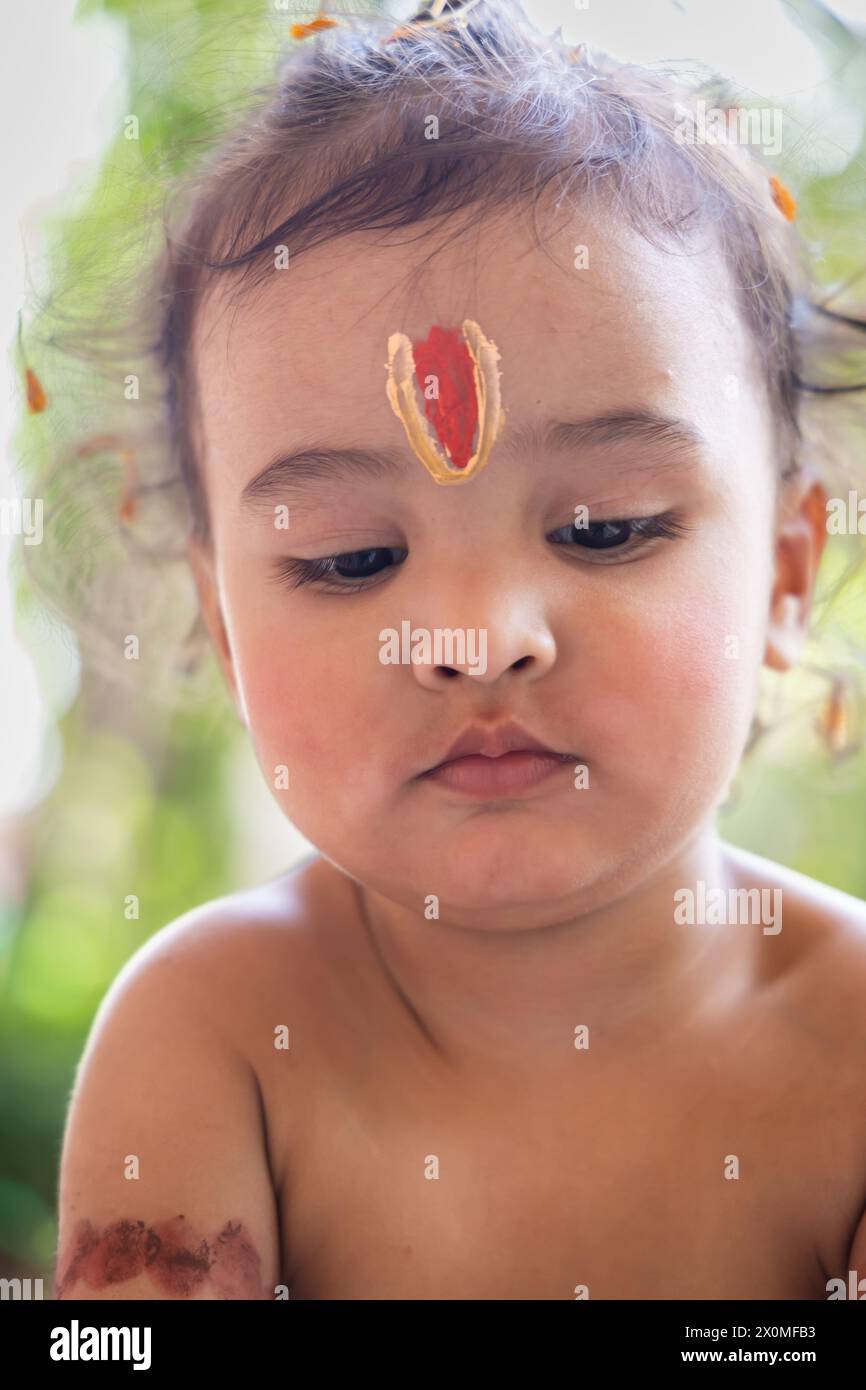 cute Indian boy with holy religious symbol on head at outdoor with