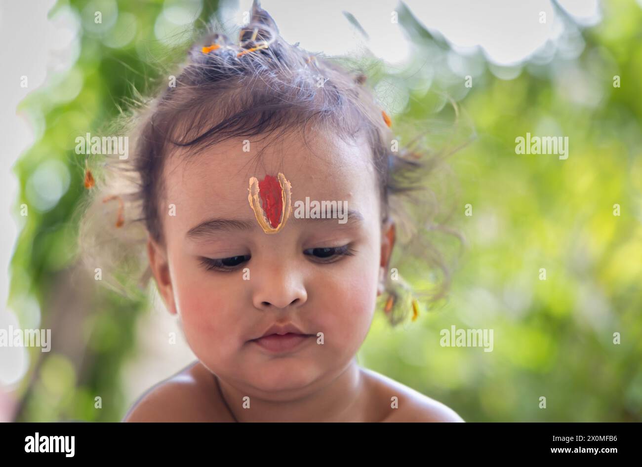 cute Indian boy with holy religious symbol on head at outdoor with