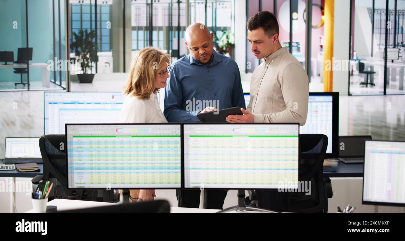 People Working With Spreadsheet Data On Computer Monitor Stock Photo