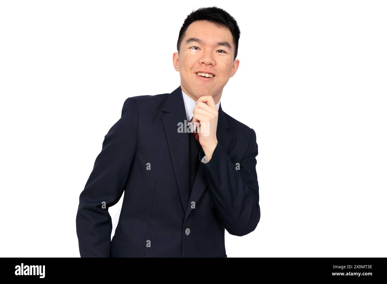 A young Asian businessman or high school or university student is posing with hand on his chin, in a thinking pose. He is wearing his school uniform, Stock Photo
