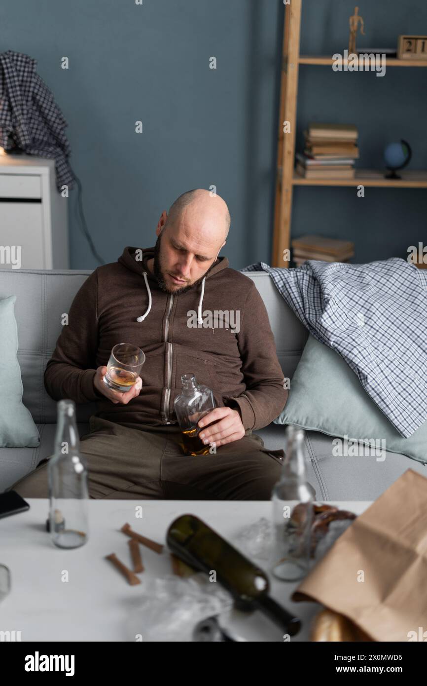 man sleep with whiskey glass on sofa, drunk or after drinking alcohol
