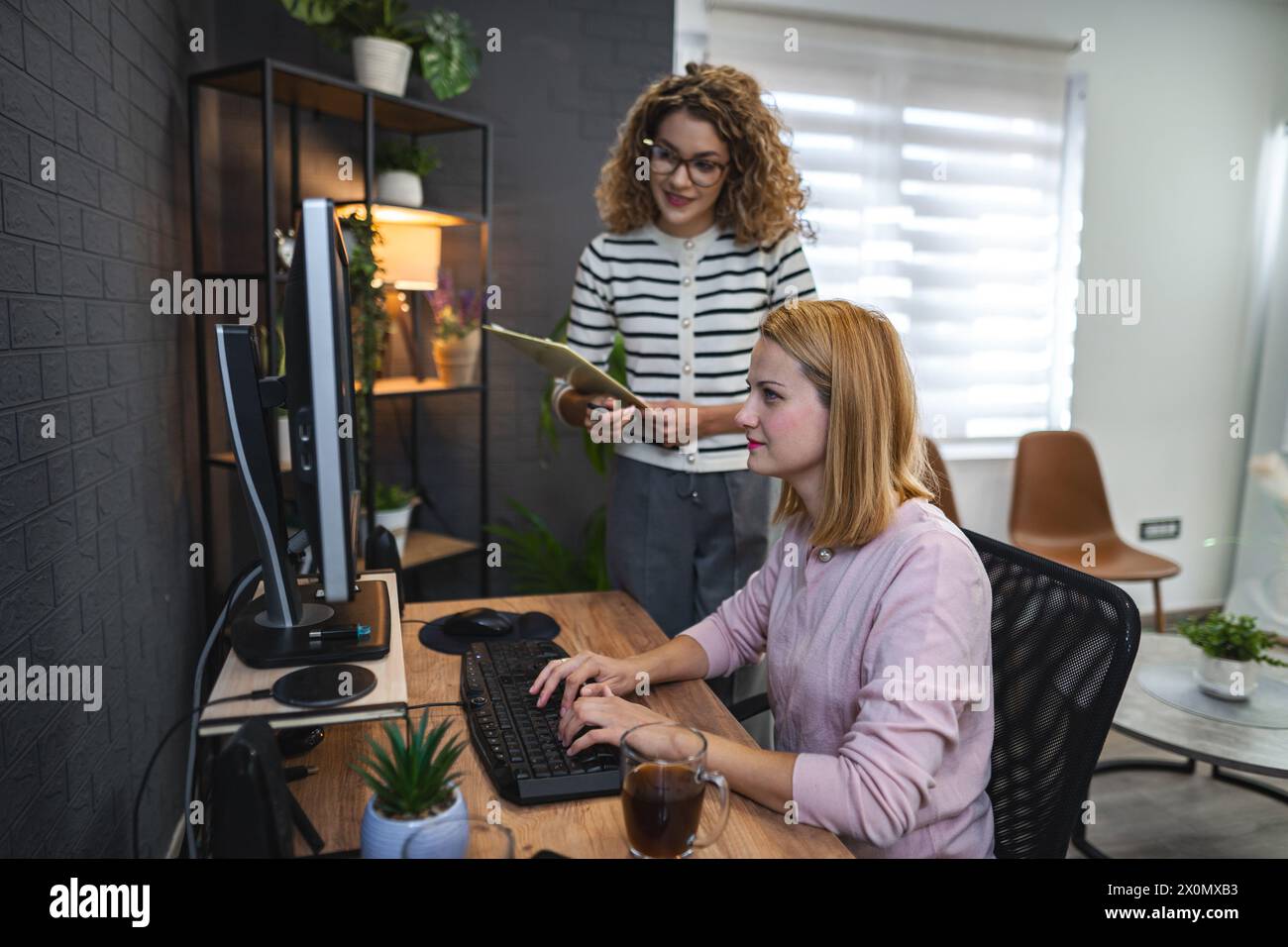 Two Women Working on a Computer in an Office Stock Photo