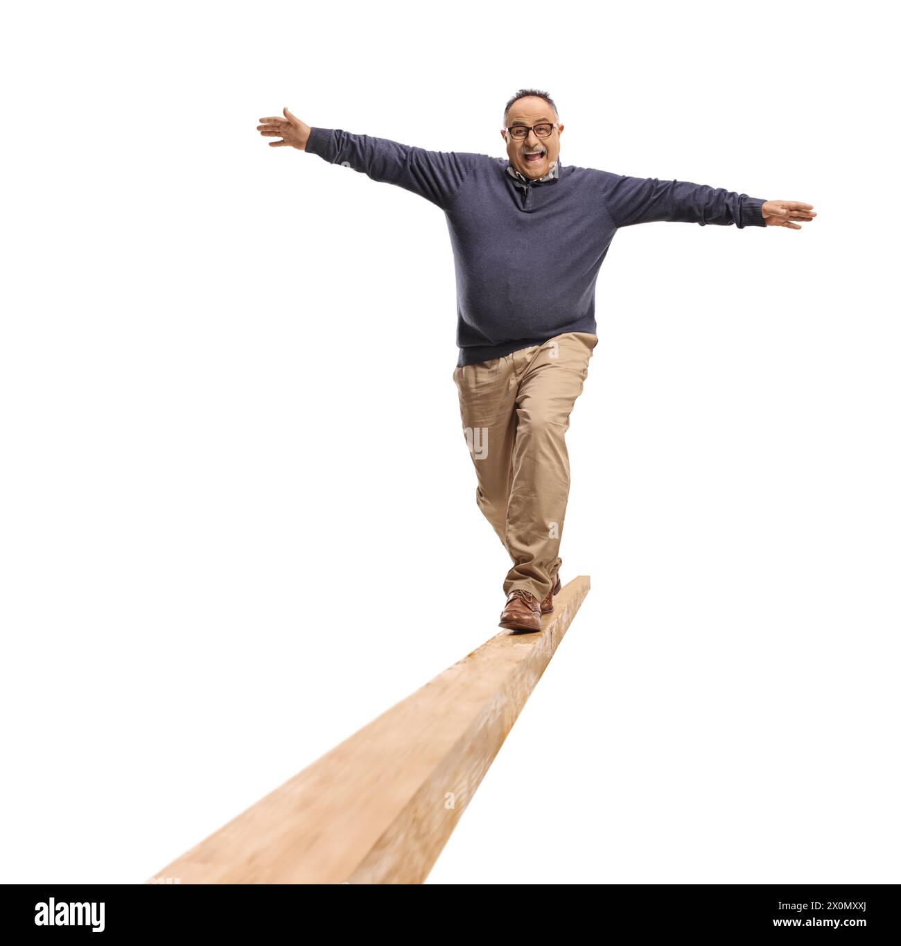Full length portrait of a mature man walking on a wooden beam isolated on white background Stock Photo
