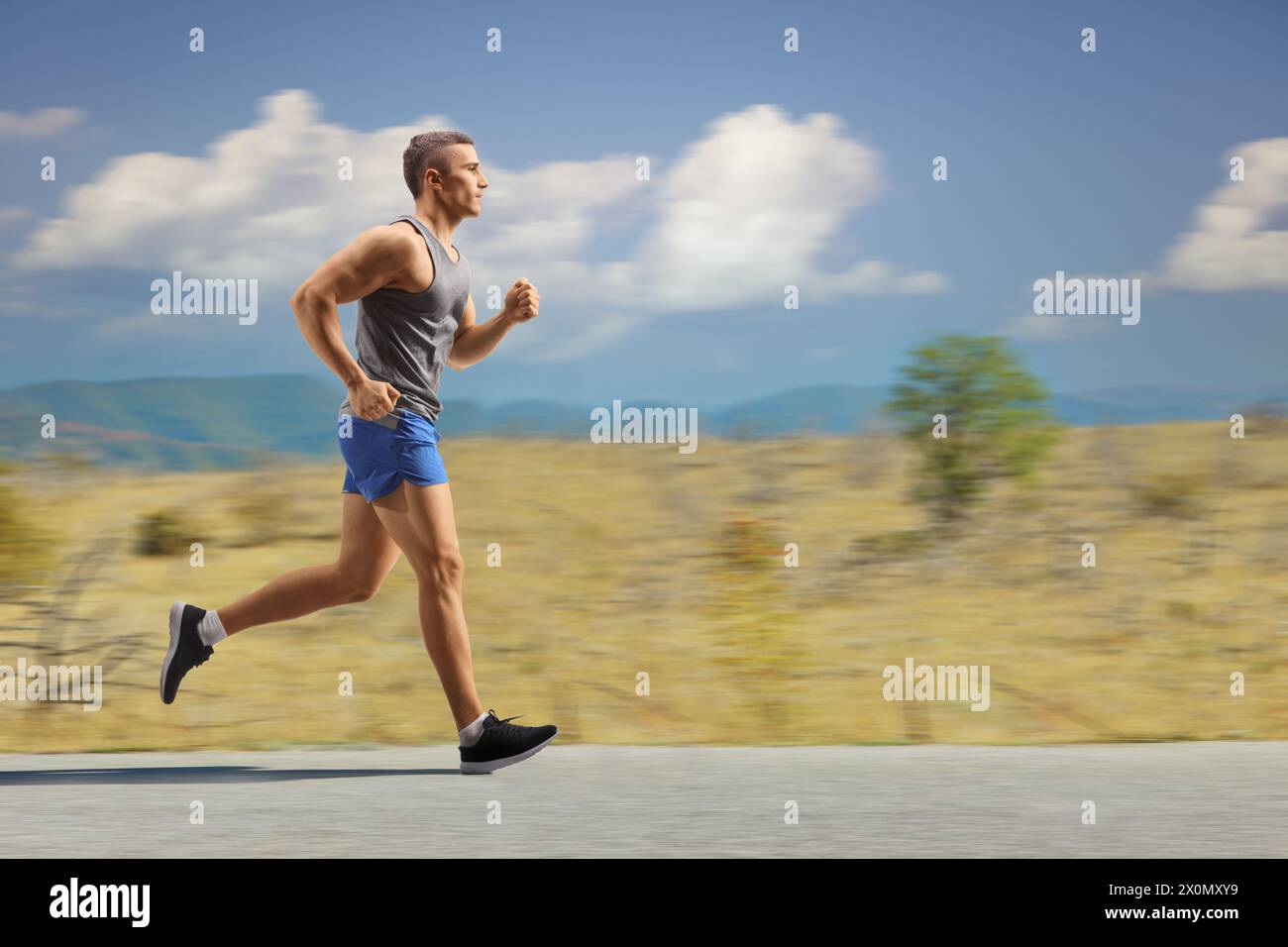 Fit young man running in nature on an open road Stock Photo