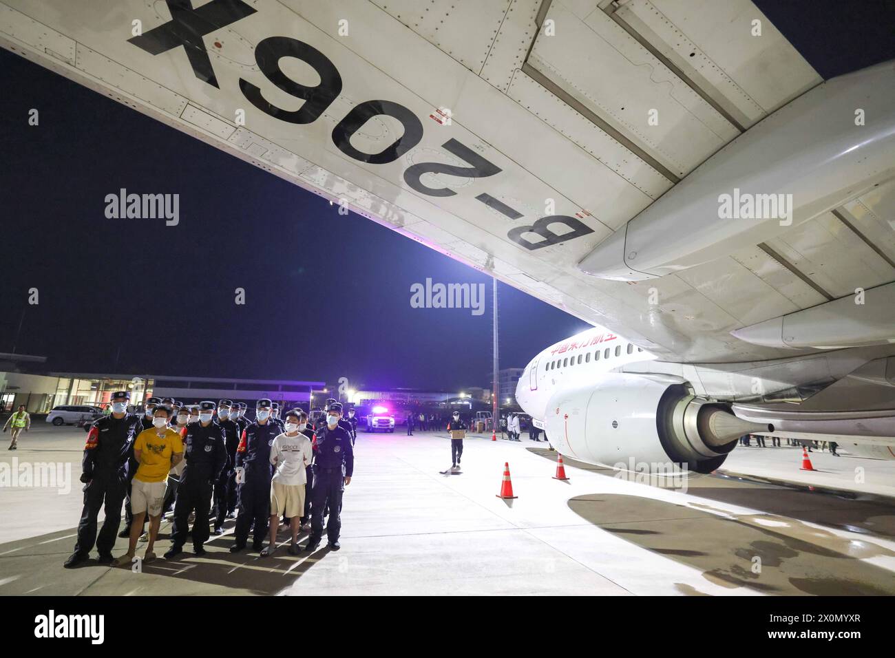 Wuhan, Cambodia. 13th Apr, 2024. Gambling and scam suspects are escorted by Chinese police officers at the Phnom Penh International Airport in Phnom Penh, Cambodia, April 13, 2024. Two police-chartered civilian flights brought back 130 gambling and scam suspects from Cambodia earlier on Saturday. This marks the first lot of suspects repatriated from Cambodia this year as Chinese and Cambodian police launched joint operations to crack down on crimes associated with gambling and swindling. Credit: Yin Gang/Xinhua/Alamy Live News Stock Photo