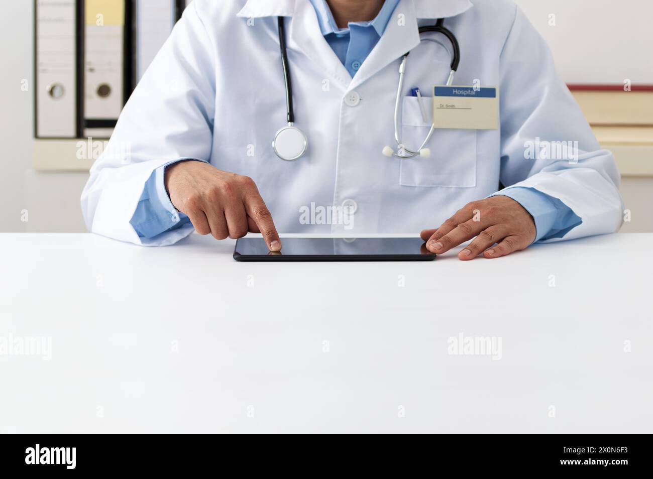 Cropped shot of a male doctor using a digital tablet in hospital office. Stock Photo