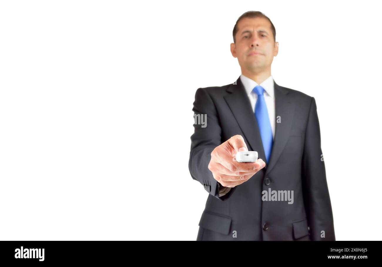 Young hispanic man with suit holding television remote control against a white background Stock Photo
