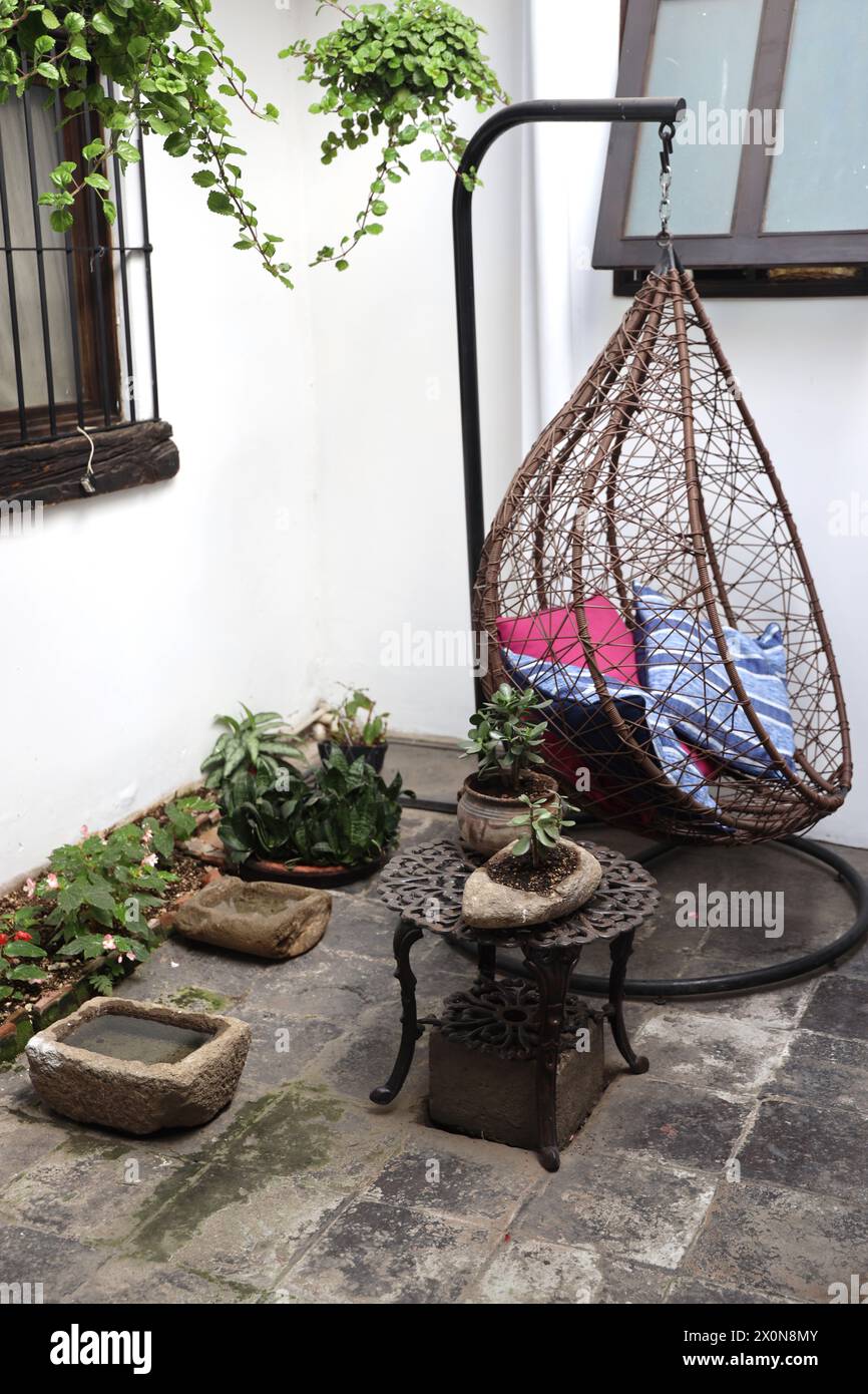 Casa Encantada . Exterior at a boutique small, intimate hotel in Antigua- Calle Poniente. Guatemala, Central America. Swing chair in a courtyard. Stock Photo