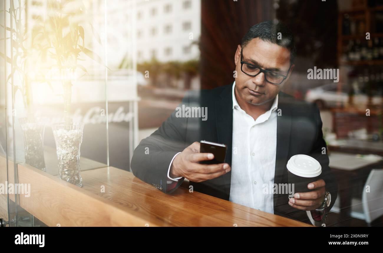 Coffee shop, business and man with smartphone, typing and texting contact for schedule and deadline. Person, employee and entrepreneur with morning Stock Photo
